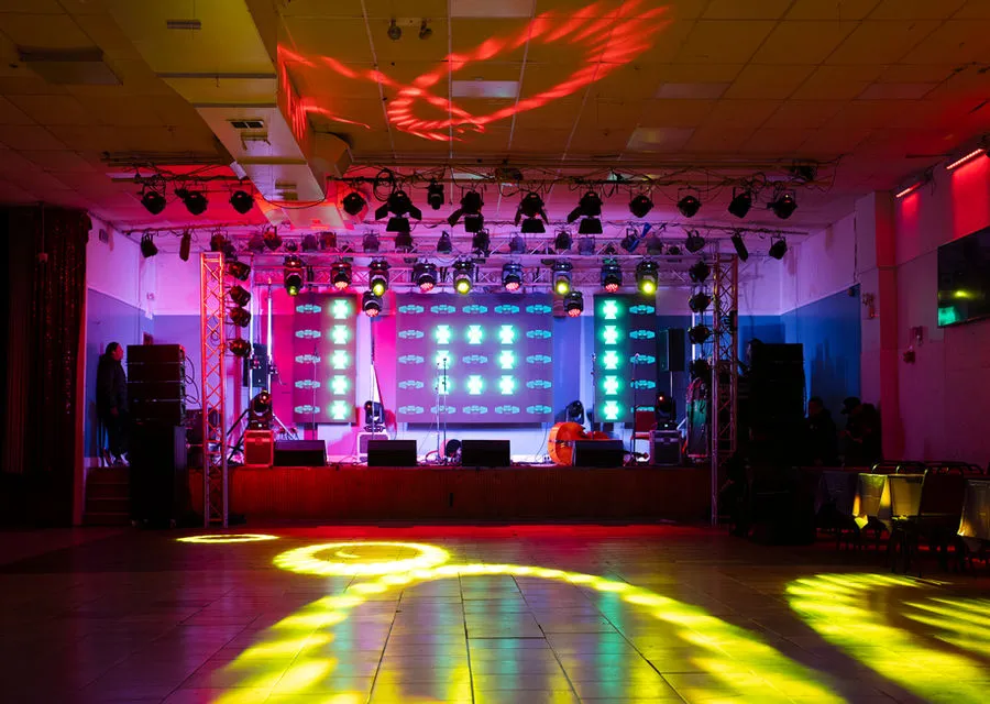 Indoor event stage with lighting and a video display