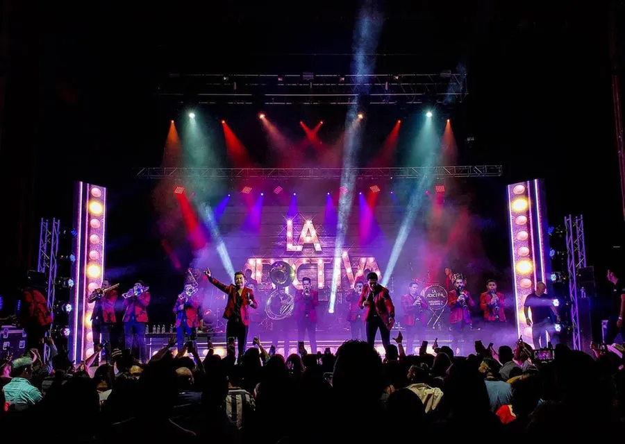 Band performing on a stage with vivid live lighting